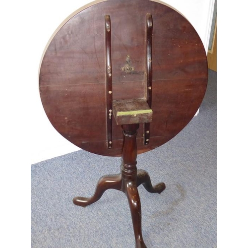 920 - A George III period circular mahogany tilt-top occasional table; two piece top above turned stem and... 