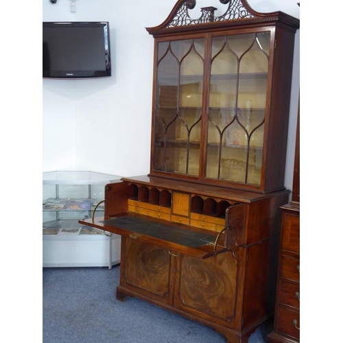 928 - An 18th century mahogany secretaire bookcase; the broken swan-neck pediment pierced in open fretwork... 