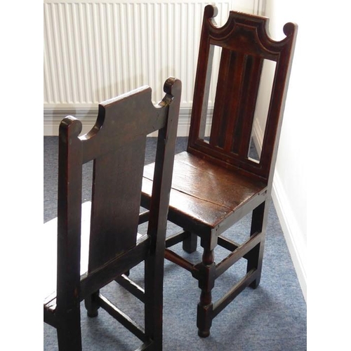 933 - A pair of late 17th/early 18th century oak side chairs; each with shaped crest rail, vertical splats... 