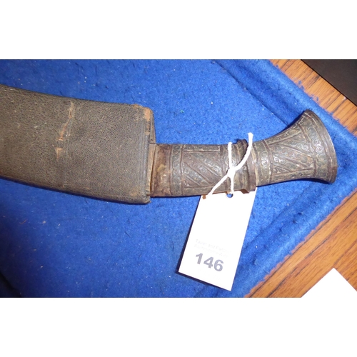 146 - A Ghurka-style Kukri in scabbard; the metal handle decorated with circular scrolls within vertical a... 