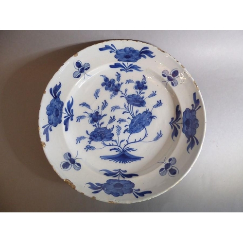 2 - A large 18th century circular tin-glazed earthenware dish; hand painted in blue and white