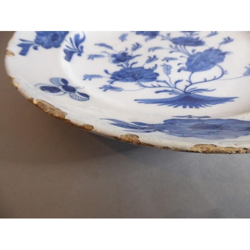 2 - A large 18th century circular tin-glazed earthenware dish; hand painted in blue and white