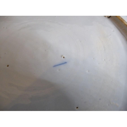 2 - A large 18th century circular tin-glazed earthenware dish; hand painted in blue and white