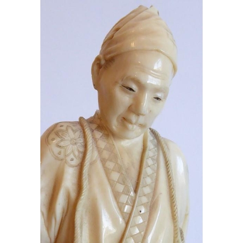 240 - A very finely carved Japanese Meiji period ivory carving depicting a male figure holding a woven wic... 