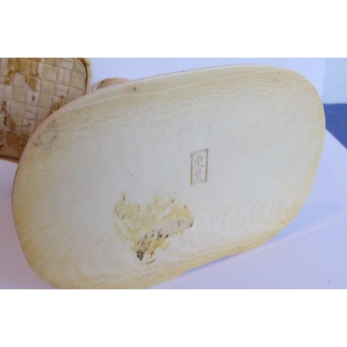 240 - A very finely carved Japanese Meiji period ivory carving depicting a male figure holding a woven wic... 