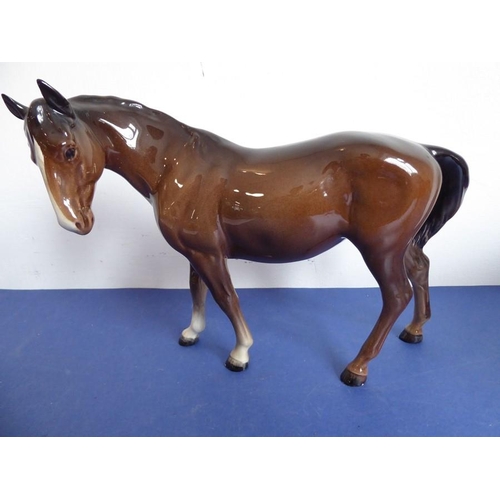 25 - Two Beswick horses; brown glaze, one standing four square the other walking and with head turned to ... 