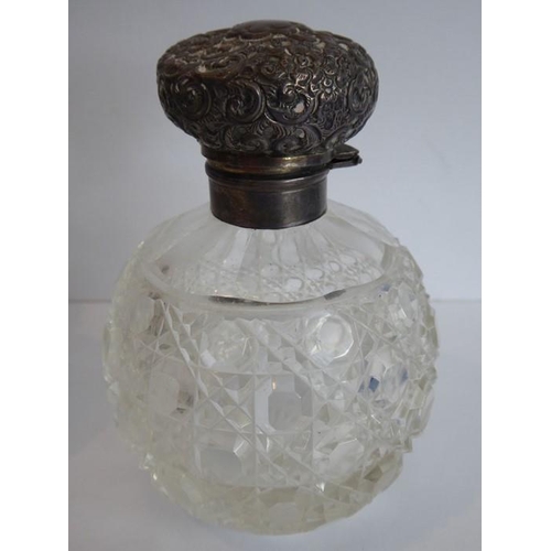 40 - A pair of early 20th century spherical cut-glass silver-mounted scents; the hinged lids decorated in... 