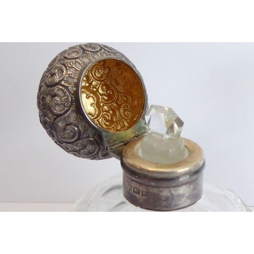 40 - A pair of early 20th century spherical cut-glass silver-mounted scents; the hinged lids decorated in... 