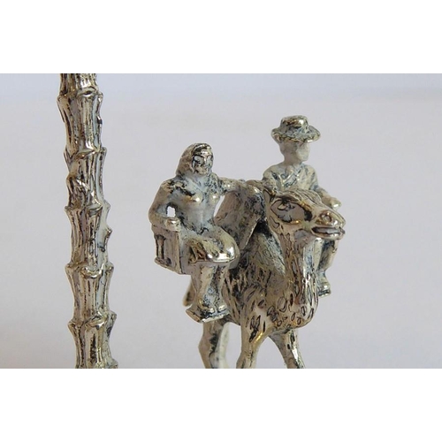 148 - An unusual solid silver model of male and female figures seated in a double howdah upon a camel's ba... 