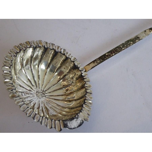 157 - An early 19th century silver and whalebone toddy ladle; the scallop-edged bowl to the monogrammed sh... 