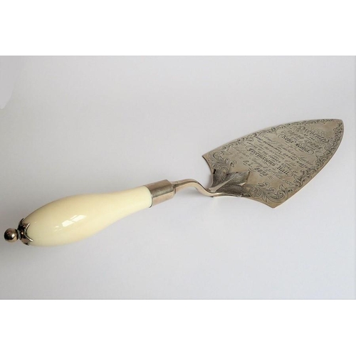 180 - A late 19th century silver and ivory-handled presentation trowel; the script within the foliate scro... 