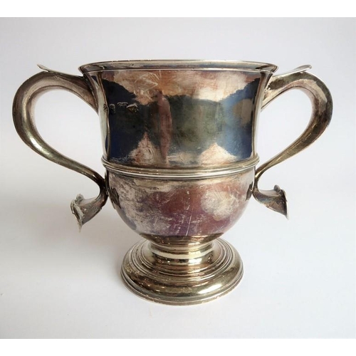 186 - A hallmarked silver two-handled loving cup; the handle terminals modelled as hearts, raised on sprea... 