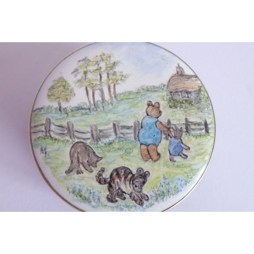 187 - A circular silver and enamel box; the enamelled lid depicting Winnie the Pooh, Piglet, Tigger and Ee... 