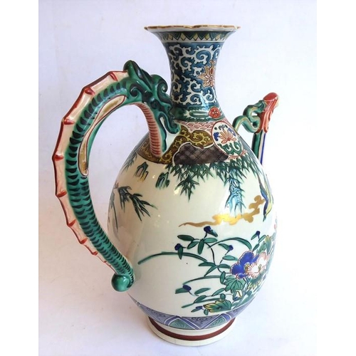 19 - An early 20th century Japanese wine ewer decorated in the Satsuma style; the curling handle modelled... 