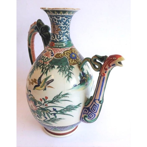 19 - An early 20th century Japanese wine ewer decorated in the Satsuma style; the curling handle modelled... 