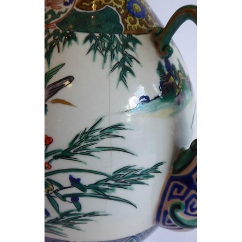 19 - An early 20th century Japanese wine ewer decorated in the Satsuma style; the curling handle modelled... 