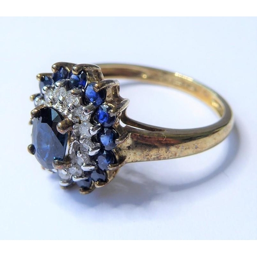 205 - A sapphire and diamond set cluster ring; the central oval mixed-cut sapphire above a surround of bri... 