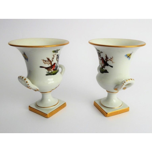 21 - A pair of Herend porcelain two-handled campana-style urns; hand gilded and decorated with differing ... 