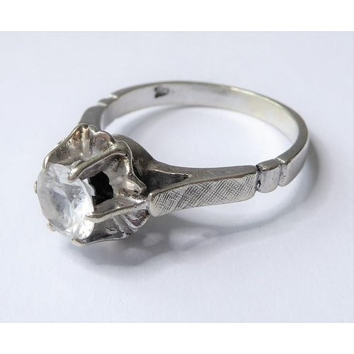 214 - A white stone ring, the circular-cut stone coronet-set above the textured shoulders and plain shank ... 