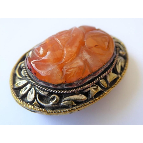 215 - A Chinese hardstone clip brooch, the central oval carved agate within the scrolling foliate bezel, t... 