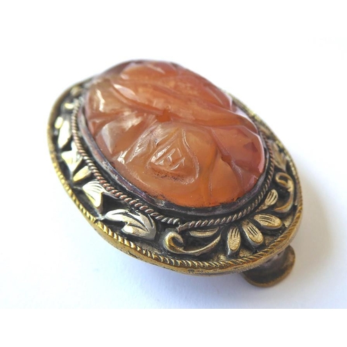 215 - A Chinese hardstone clip brooch, the central oval carved agate within the scrolling foliate bezel, t... 