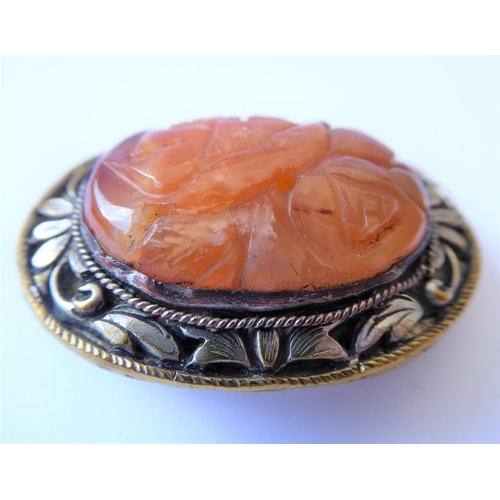 215 - A Chinese hardstone clip brooch, the central oval carved agate within the scrolling foliate bezel, t... 