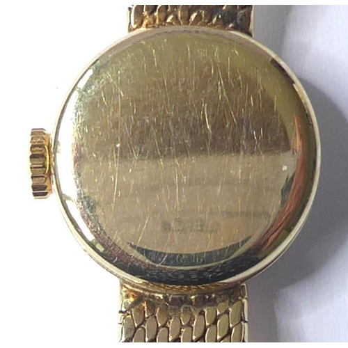 229 - A lady's 9-carat yellow-gold wristwatch by Omega; the champagne-coloured dial with baton markers sig... 