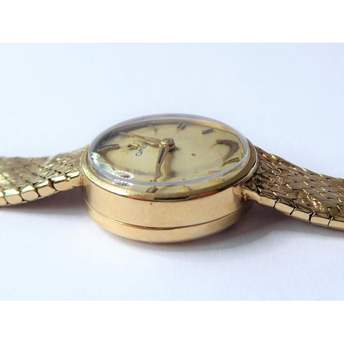 229 - A lady's 9-carat yellow-gold wristwatch by Omega; the champagne-coloured dial with baton markers sig... 