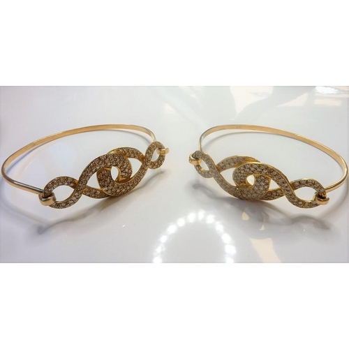 233 - A pair of diamond-set sprung bangles; each top section of entrelac brilliant-cut diamonds design, cl... 