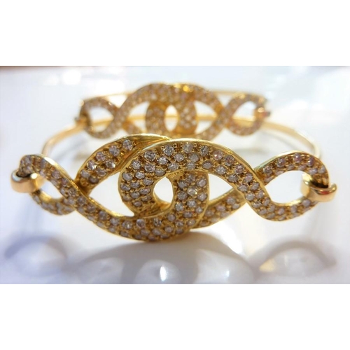 233 - A pair of diamond-set sprung bangles; each top section of entrelac brilliant-cut diamonds design, cl... 