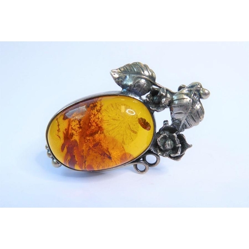 238 - Two amber bead and 'nugget' necklaces, one further and an oval amber brooch within a scrolling surro... 