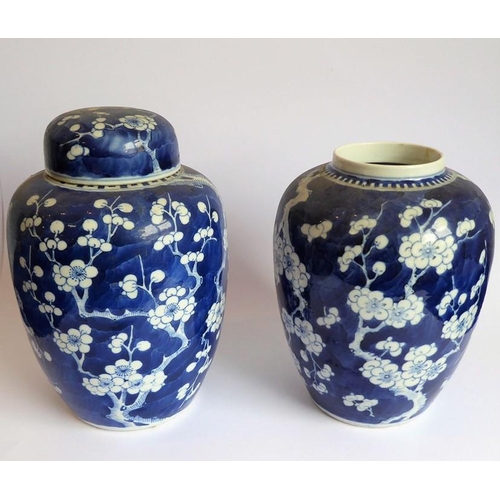 24 - A pair of late 19th century Chinese baluster-shaped vases in Kangxi-style (one minus lid); each piec... 