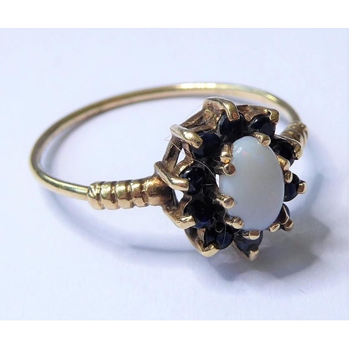 243 - A cabochon opal and sapphire-set cluster ring to the 9 carat yellow gold ornate shoulders and wirewo... 