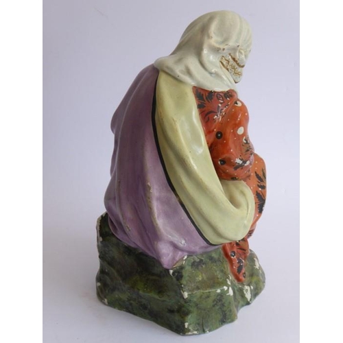 26 - A large early to mid-19th century hand-decorated Staffordshire-style porcelain figure; a seated moth... 