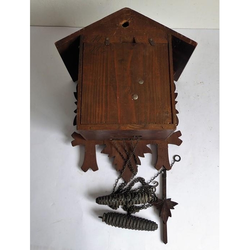 267 - A mid-20th century carved Swiss or Black Forest cuckoo clock with pediment, pendulum and pinecone-sh... 