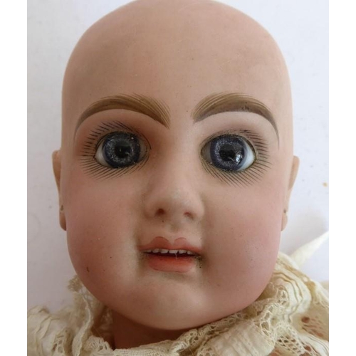 327 - A late 19th century bisque head doll; the back of the head stamped in red 'Tête Juméau'; curly blond... 