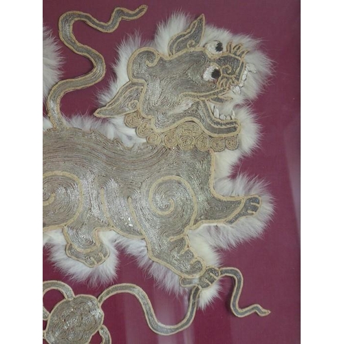 355 - A gilt framed and glazed animal fur and silver wire needlework depicting a Qilin upon a symbolic Bud... 