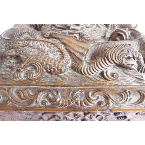 361 - A 19th century oak casket; heavily carved in relief with a marine theme, with a central cherubic fig... 