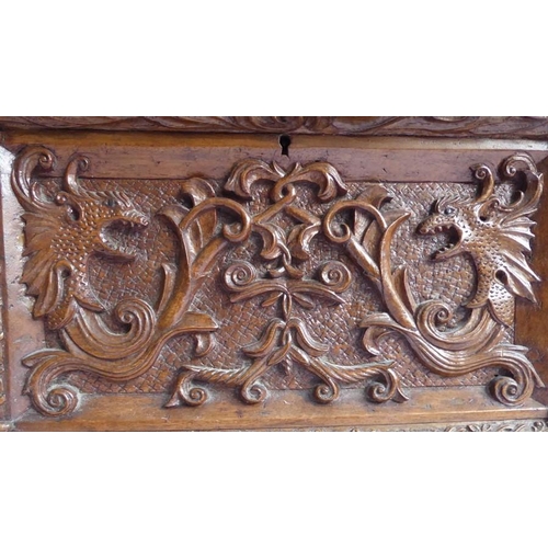 361 - A 19th century oak casket; heavily carved in relief with a marine theme, with a central cherubic fig... 