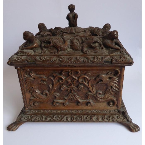 361 - A 19th century oak casket; heavily carved in relief with a marine theme, with a central cherubic fig... 