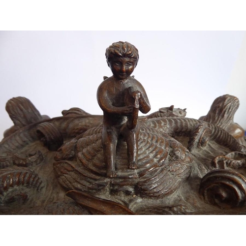 361 - A 19th century oak casket; heavily carved in relief with a marine theme, with a central cherubic fig... 