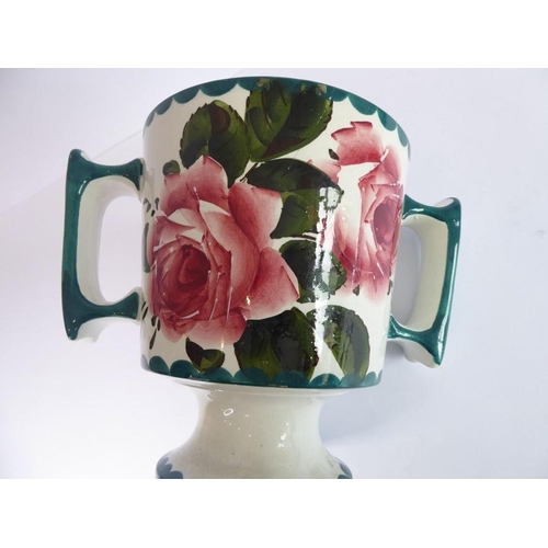 38 - An early 20th century two-handled Wemyss Pottery loving cup; hand-decorated with roses, stamped Wemy... 