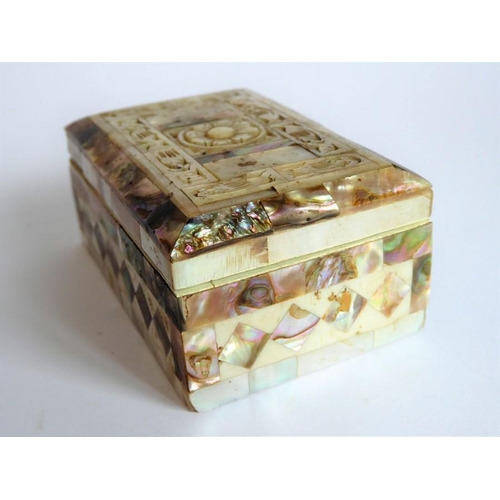 388 - An ornate mother of pearl inlaid box; the hinged lid opening to reveal a red lining (9.25cm wide)