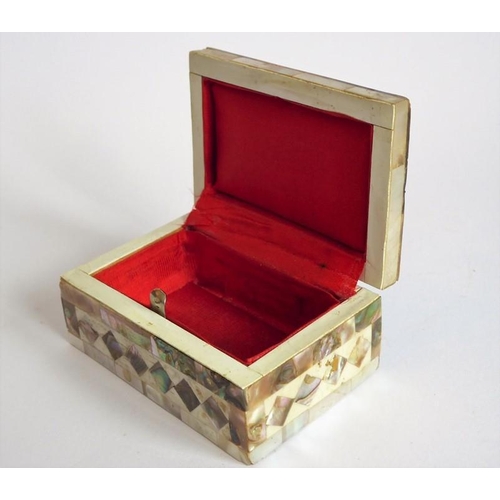 388 - An ornate mother of pearl inlaid box; the hinged lid opening to reveal a red lining (9.25cm wide)