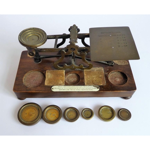 396 - A set of 19th century brass postal scales with weights and raised upon a mahogany plinth base (27cm ... 