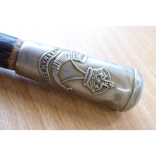 402 - An early 20th century ebonised swagger stick; the finial with the badge of the Cheltenham College Of... 