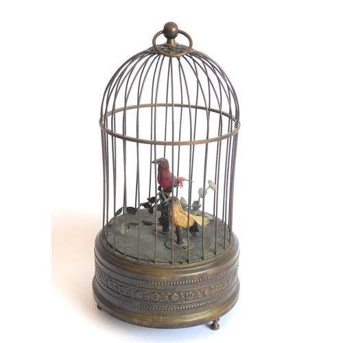 407 - An early 20th century brass-cased, dome-topped singing birdcage automaton; the round suspension loop... 