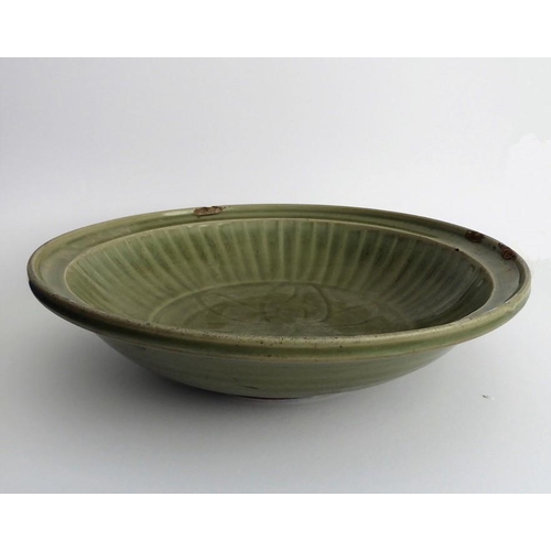 42 - A large early 17th century Chinese Longquan bowl with celadon glaze; the moulded lip above a central... 