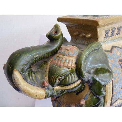 44 - A large Chinese stoneware jardinière stand modelled as a trumpeting elephant; the central howdah res... 