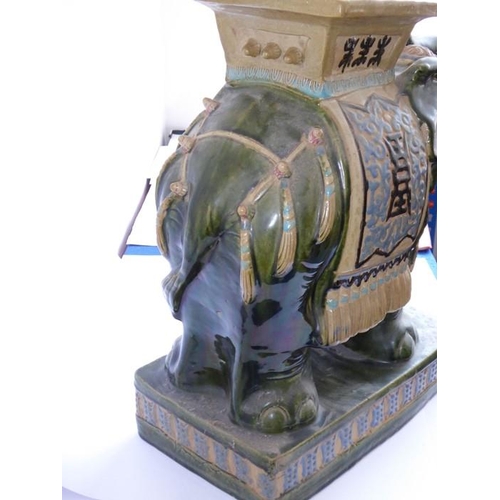 44 - A large Chinese stoneware jardinière stand modelled as a trumpeting elephant; the central howdah res... 